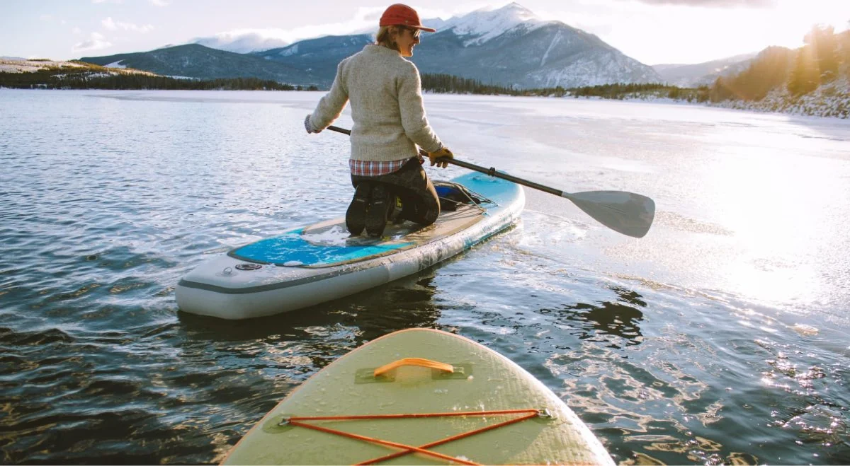 A person paddleboarding on a mountain lake