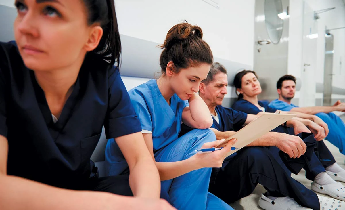 Healthcare workers resting in a hospital hallway